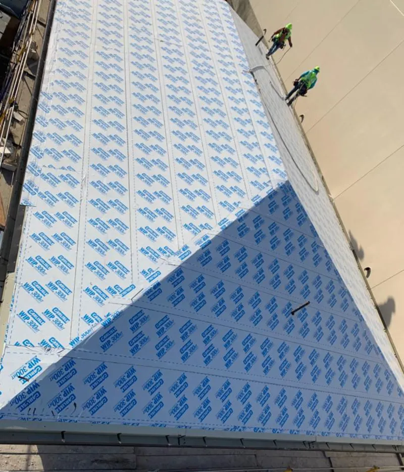 Professional roofers installing underlayment on a metal roof in Channahon